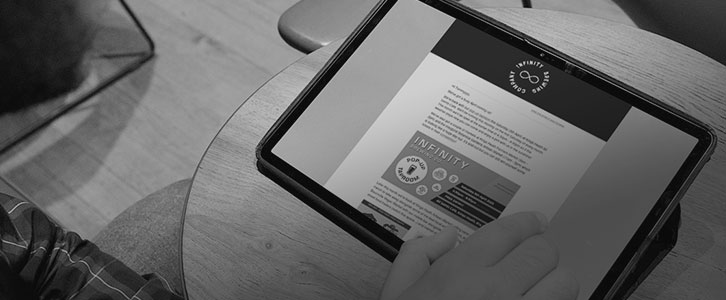 Person reading an Infinity newsletter on a tablet